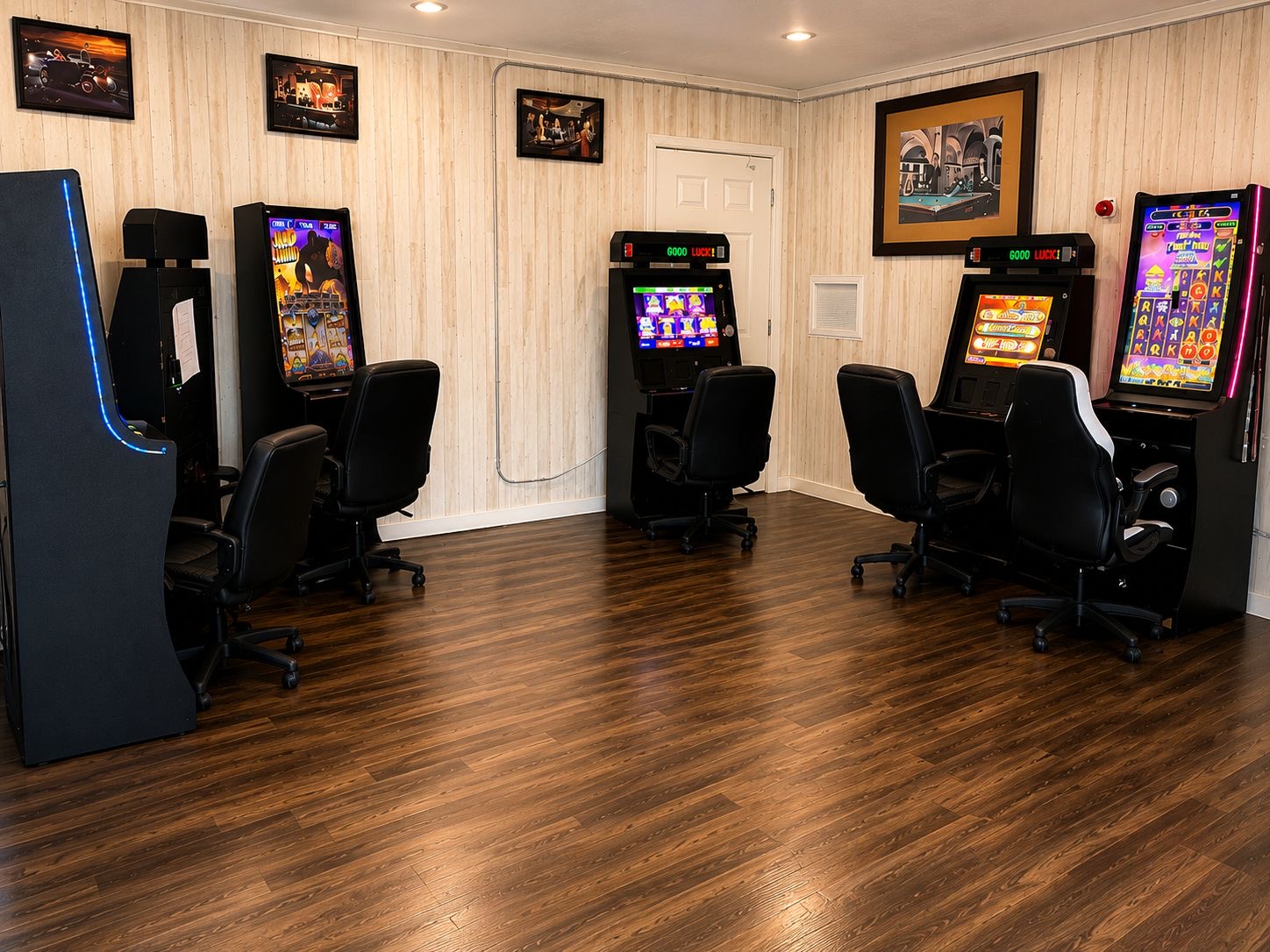 Sala de juegos con maquinitas, sillas gamer y mesa.